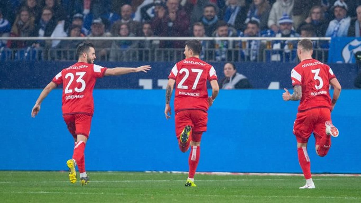 Die Düsseldorfer Niko Gießelmann, Dawid Kownacki und André Hoffmann (l-r) feiern den vierten Treffer auf Schalke.