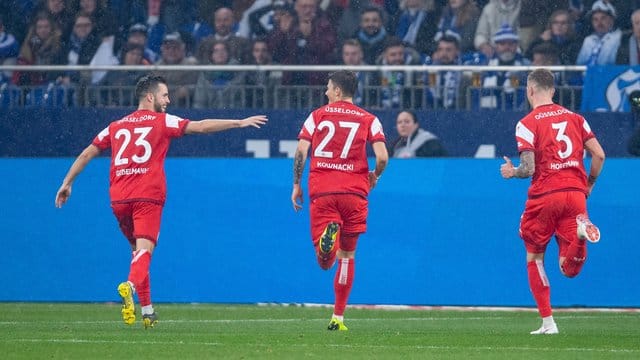 Die Düsseldorfer Niko Gießelmann, Dawid Kownacki und André Hoffmann (l-r) feiern den vierten Treffer auf Schalke.