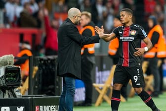 Leverkusens Trainer Peter Bosz klatscht mit Leon Patrick Bailey ab, dem Torschützen zum 2:0 gegen Freiburg.