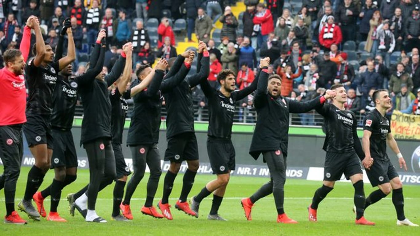 Die Spieler von Eintracht Frankfurt feiern mit den Fans den späten Sieg über 1899 Hoffenheim.