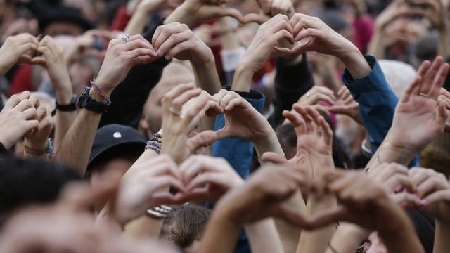 Demonstranten formen Herzen mit ihren Händen während eines Protests gegen Rassismus in Mailand. Demonstranten formen Herzen mit ihren Händen während eines Protests gegen Rassismus in Mailand.