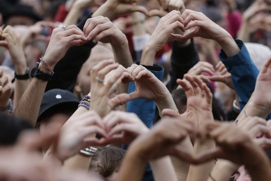Demonstranten formen Herzen mit ihren Händen während eines Protests gegen Rassismus in Mailand.