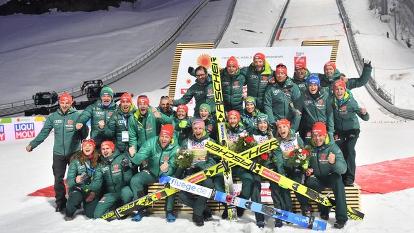 Das deutsche Skisprungteam feiert mit dem Mixed-Team deren Sieg.