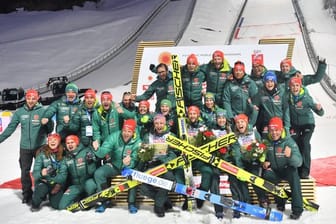 Das deutsche Skisprungteam feiert mit dem Mixed-Team deren Sieg.