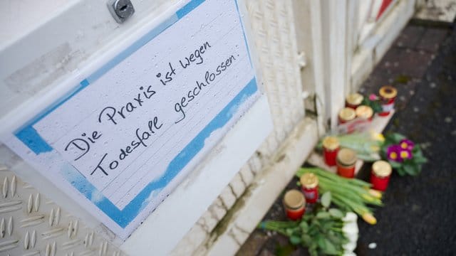 Vor dem Haus des getöteten Arztes liegen Blumen und sind Kerzen abgestellt.