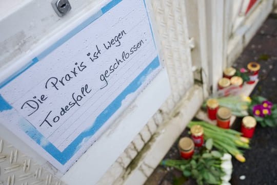 Vor dem Haus des getöteten Arztes liegen Blumen und sind Kerzen abgestellt.