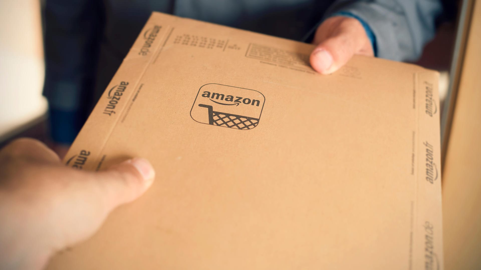 Ein Amazon-Päckchen wird übergeben: Die Handelsplattform will Geschäfte mit gekauften Kundenrezensionen unterbinden. Ein Amazon-Päckchen wird übergeben: Die Handelsplattform will Geschäfte mit gekauften Kundenrezensionen unterbinden.