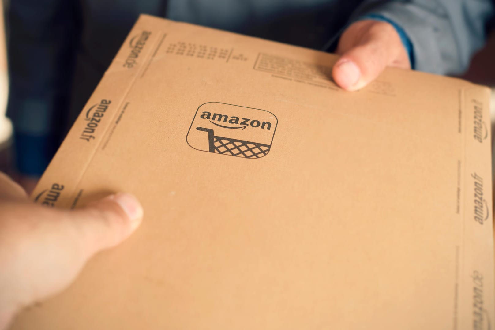 Ein Amazon-Päckchen wird übergeben: Die Handelsplattform will Geschäfte mit gekauften Kundenrezensionen unterbinden.