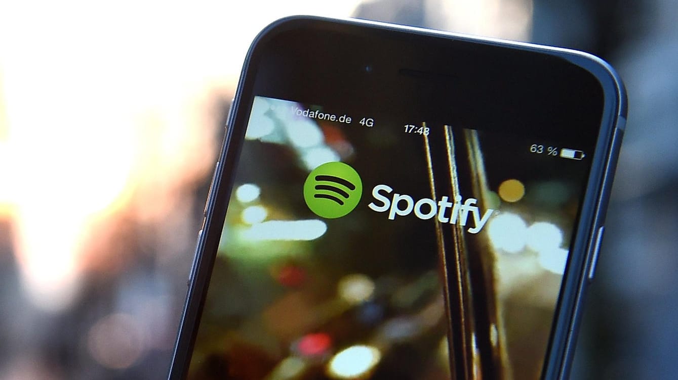 Auf dem Display eines iPhone 6 wird die App von Spotify angezeigt: Spotify will seine Position im deutschen Podcast-Markt mit neuen, exklusiv verfügbaren Sendungen weiter ausbauen.