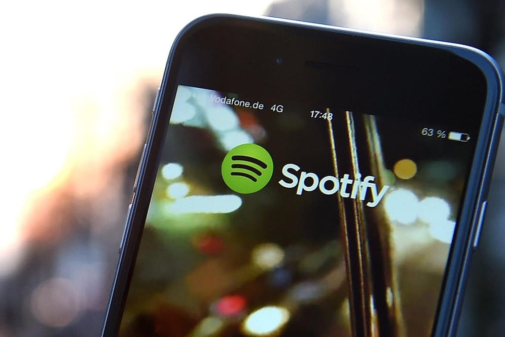 Auf dem Display eines iPhone 6 wird die App von Spotify angezeigt: Spotify will seine Position im deutschen Podcast-Markt mit neuen, exklusiv verfügbaren Sendungen weiter ausbauen.
