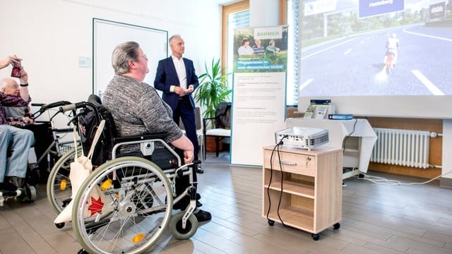 Ingelore Leppin, Bewohnerin im Alten- und Pflegeheim Heinemanhof, fährt mit der Spielekonsole "MemoreBox" auf einem Motorrad.