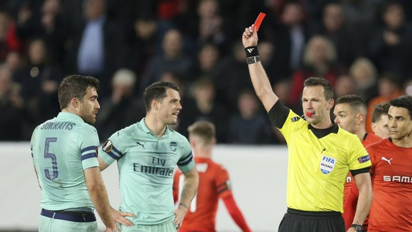 Schiedsrichter Slowake Ivan Kruzliak zeigt Arsenals Sokratis(l) die Rote Karte.