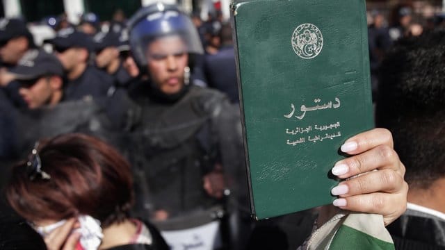 Eine Demonstrantin hält eine Kopie der algerischen Verfassung hoch während eines Protestmarsches gegen die Entscheidung des algerischen Präsidenten Bouteflika, trotz angeschlagener Gesundheit für eine fünfte Amtszeit zu kandidieren. Eine Demonstrantin hält eine Kopie der algerischen Verfassung hoch während eines Protestmarsches gegen die Entscheidung des algerischen Präsidenten Bouteflika, trotz angeschlagener Gesundheit für eine fünfte Amtszeit zu kandidieren.