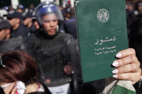 Eine Demonstrantin hält eine Kopie der algerischen Verfassung hoch während eines Protestmarsches gegen die Entscheidung des algerischen Präsidenten Bouteflika, trotz angeschlagener Gesundheit für eine fünfte Amtszeit zu kandidieren.