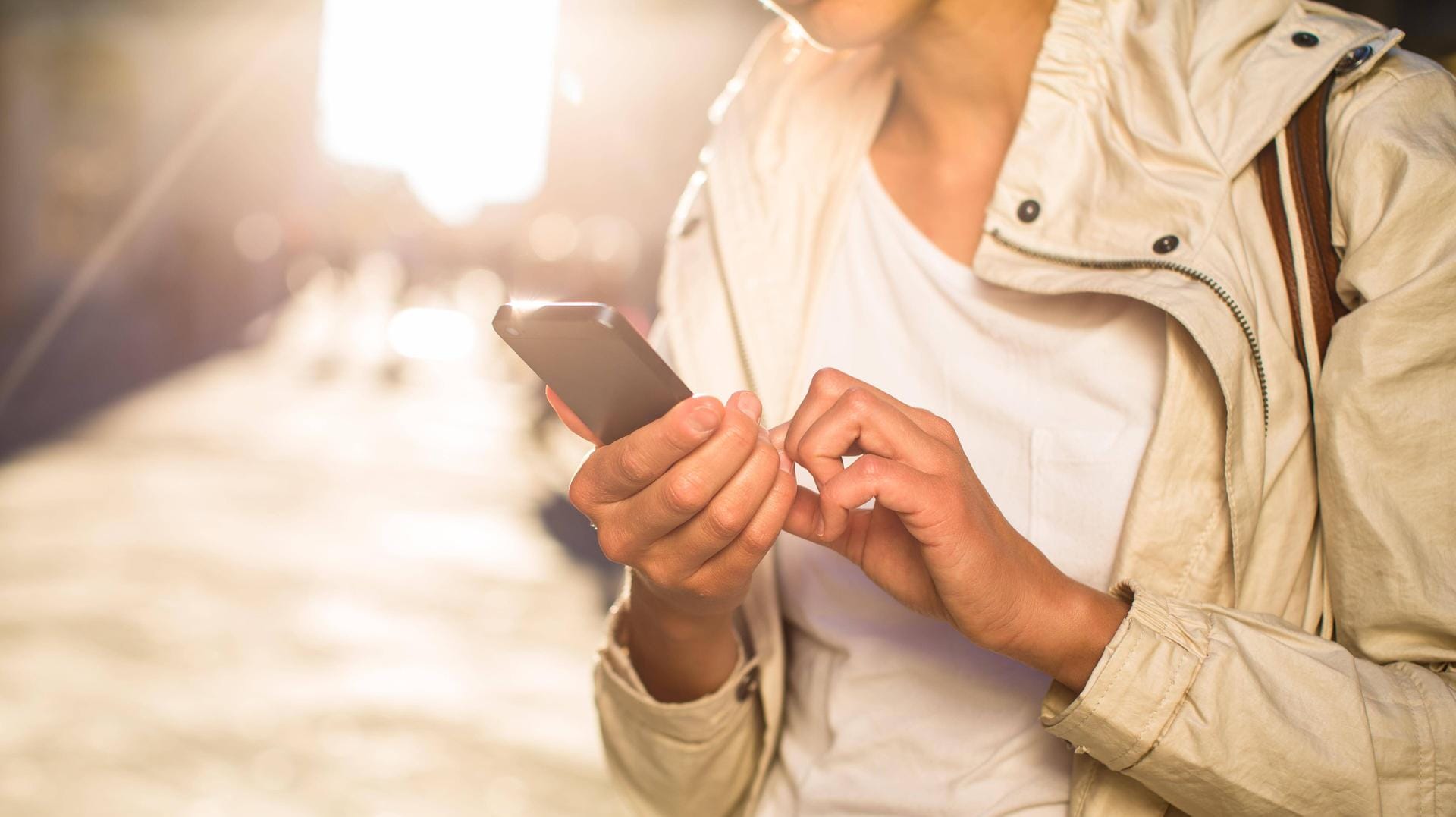 Eine junge Frau surft auf ihrem Smartphone: Noch immer profitiert nicht jeder Handynutzer vom schnellen LTE-Netz.