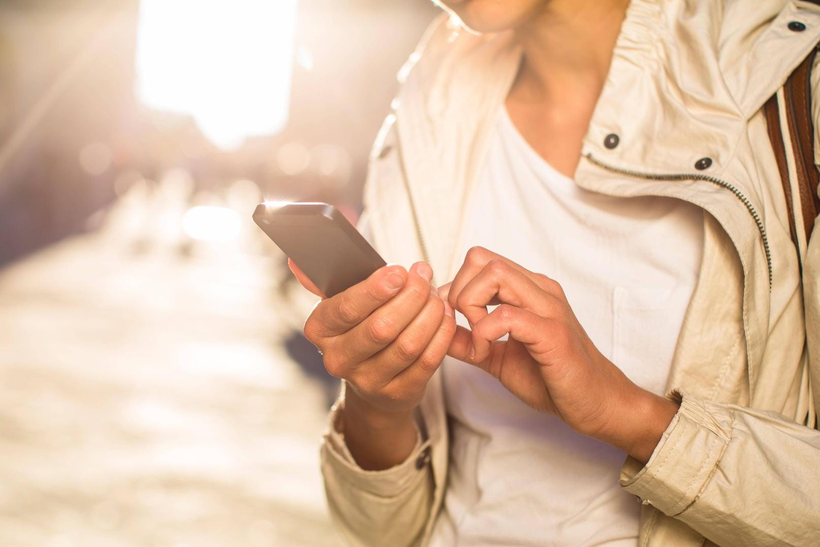 Eine junge Frau surft auf ihrem Smartphone: Noch immer profitiert nicht jeder Handynutzer vom schnellen LTE-Netz.