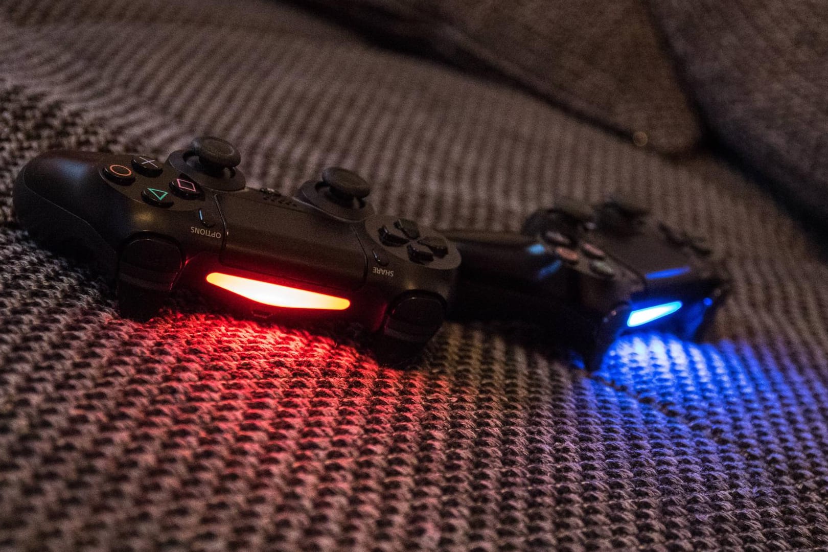 PlayStation 4-Controller liegen auf einer Couch: Dank einer neuen Apps kann die Spielekonsole auch per iPhone und iPad bedient werden.