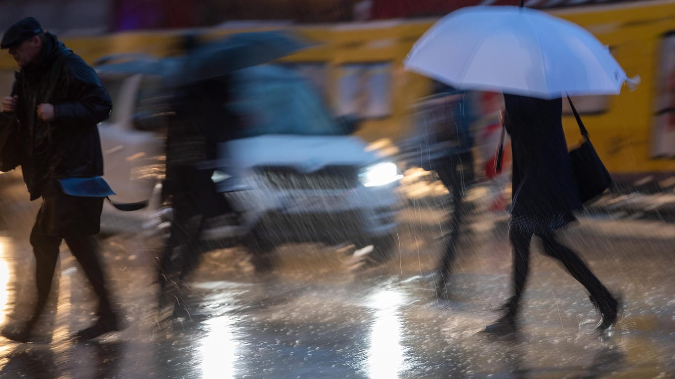 Passanten mit Regenschirmen während eines Gewitters: Das Wetter am Wochenende wird vielerorts ungemütlich.