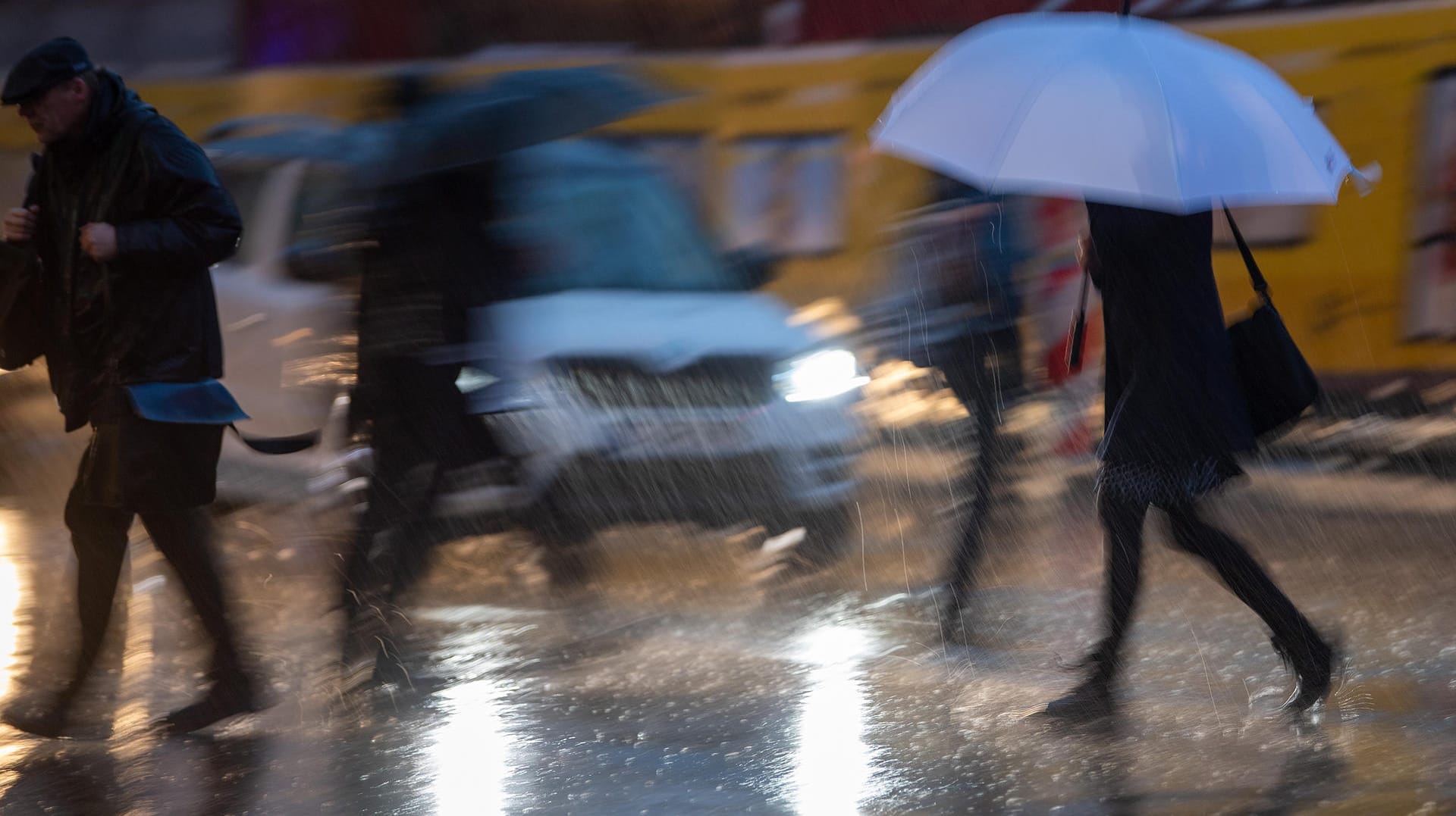 Passanten mit Regenschirmen während eines Gewitters: Das Wetter am Wochenende wird vielerorts ungemütlich. Passanten mit Regenschirmen während eines Gewitters: Das Wetter am Wochenende wird vielerorts ungemütlich.