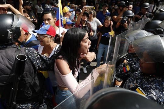 Eine Frau konfrontiert venezolanische Polizisten, die Teilnehmer einer Demonstration gegen die sozialistische Regierung von Präsident Maduro blockieren.