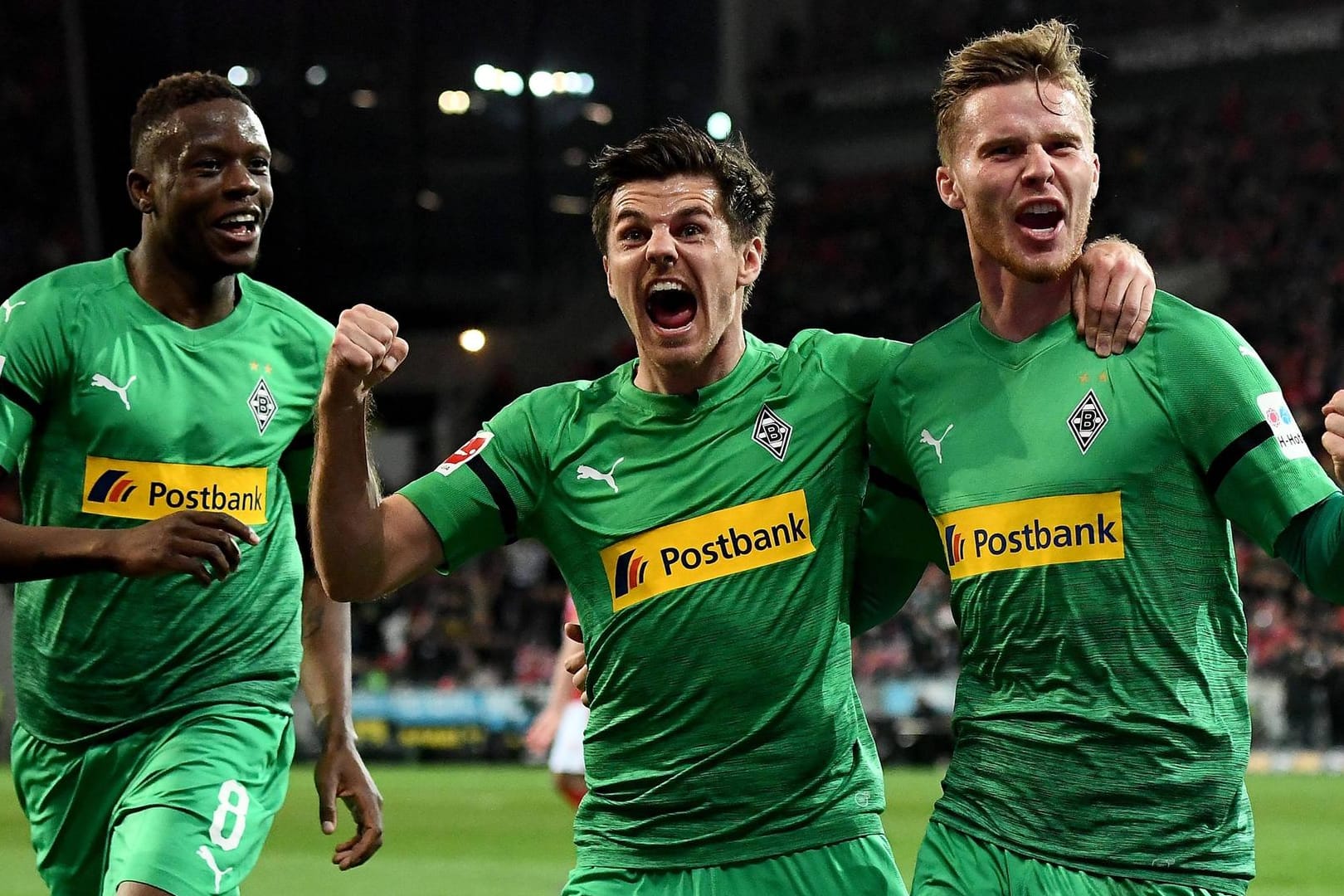 Die Gladbacher Denis Zakaria (v.l.) und Jonas Hofmann feiern mit Torschütze Nico Elvedi das 1:0.