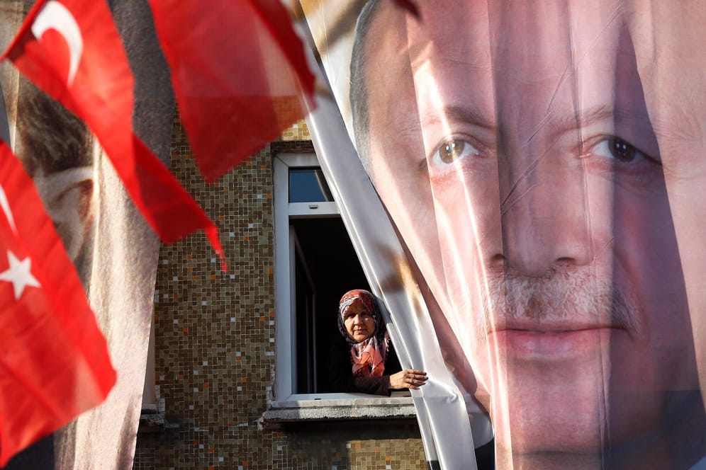 Eine Frau blickt aus ihrem Fenster hinter einem Banner des türkischen Präsidenten Erdogan: Das Auswärtige Amt hat die Reisehinweise für die Türkei verschärft.