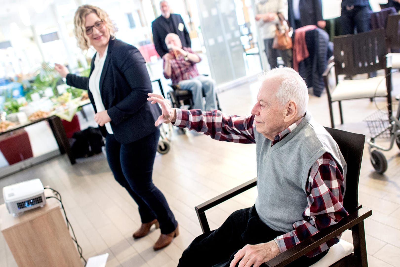 Bernhard Pischel, Bewohner des Alten- und Pflegeheims Heinemanhof, und Sandra Mehmecke, Präsidentin der Pflegekammer Niedersachsen, spielen ein Videogame auf der für Ältere entwickelten Spielekonsole "MemoreBox".