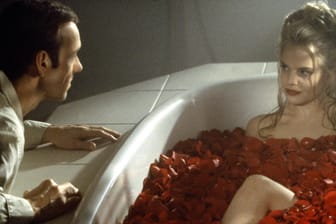 Schauspielerin liegt in einer Badewanne voller Rosen.
