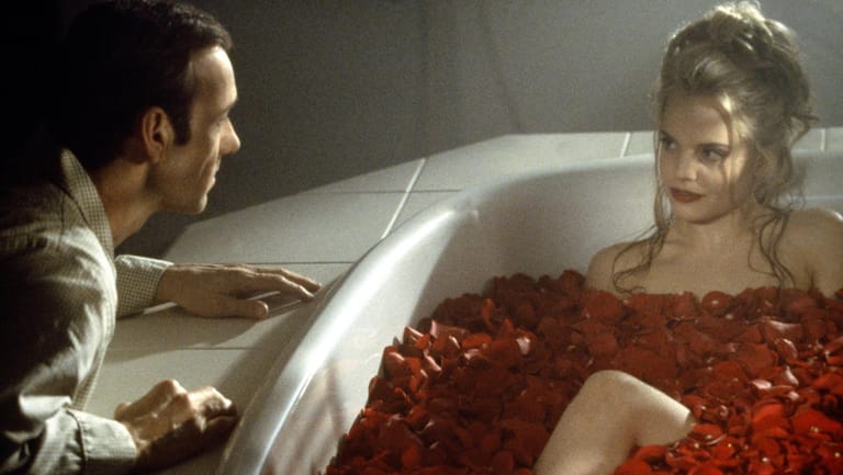 Schauspielerin liegt in einer Badewanne voller Rosen.