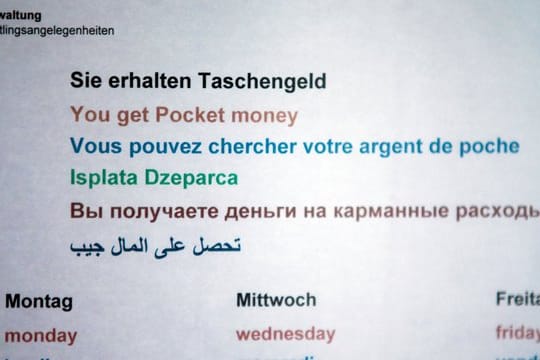 Ein Hinweisschild informiert in einer Erstaufnahmeeinrichtung für Flüchtlinge über die Zeiten der Taschengeld-Ausgabe.