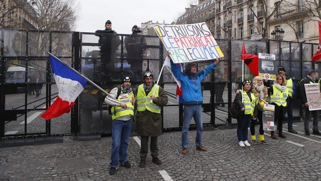 Demonstranten der "Gelbwesten"-Bewegung vor einer Straßensperre der Polizei in Paris.