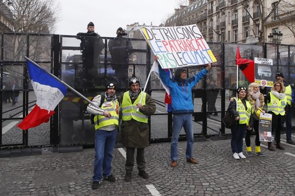 Demonstranten der "Gelbwesten"-Bewegung vor einer Straßensperre der Polizei in Paris.
