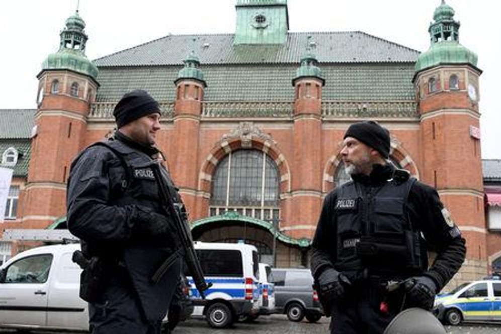 Polizeibeamte stehen vor dem Hauptbahnhof in Lübeck: Der Bahnhof wurde nach einer Bombendrohung evakuiert und der Zugverkehr eingestellt.
