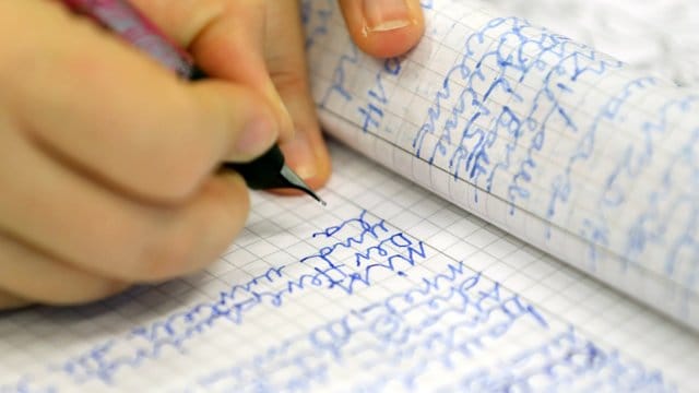 Eine Frau schreibt in der Volkshochschule Rostock bei einem Analphabeten-Grundkurs. Eine Frau schreibt in der Volkshochschule Rostock bei einem Analphabeten-Grundkurs.
