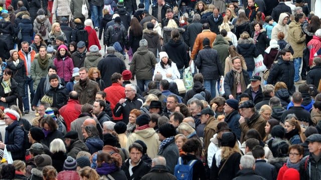 Passanten drängen sich durch die Innenstadt in München (Bayern).