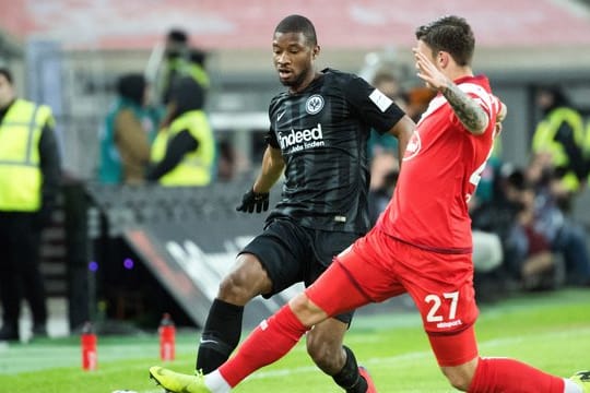 Düsseldorfs Dawid Kownacki (r) im Duell um den Ball mit Almany Toure von Eintracht Frankfurt.