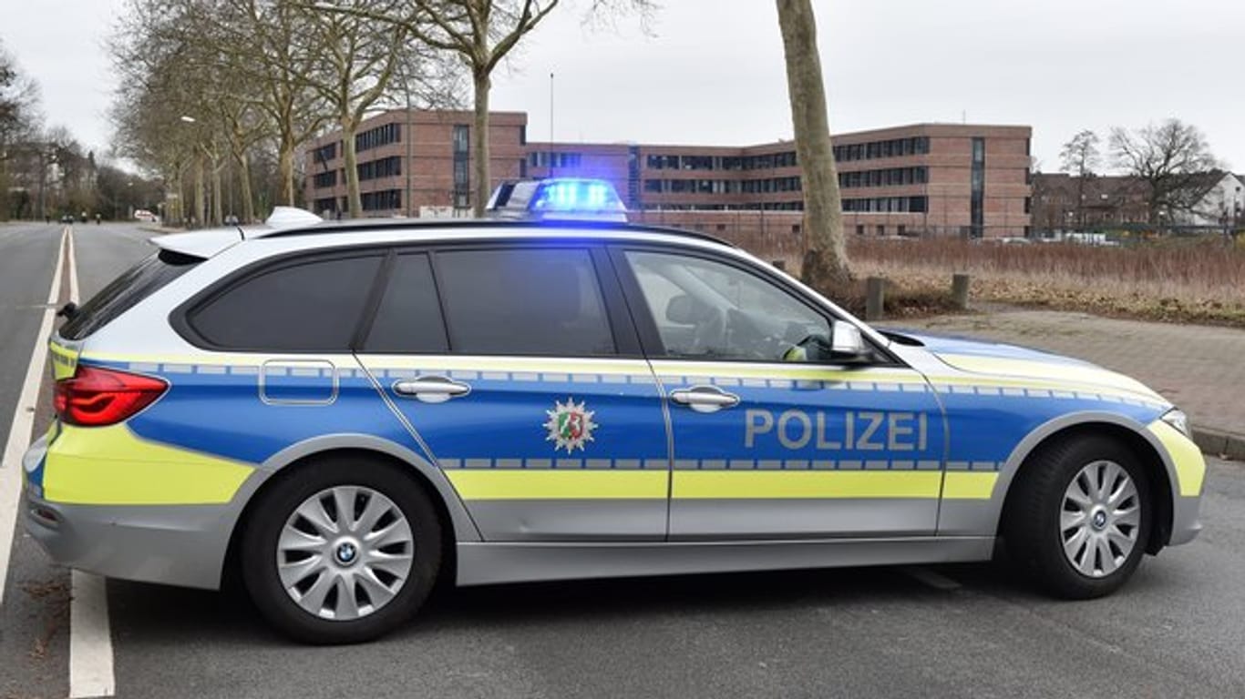 Polizeiauto auf abgesperrter Straße vor dem Finanzamt Gelsenkirchen: Sprengstoff-Spürhunde durchsuchten das Gebäude, fanden aber nichts Verdächtiges.