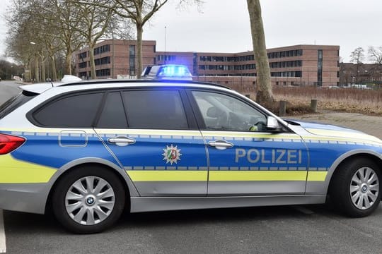 Polizeiauto auf abgesperrter Straße vor dem Finanzamt Gelsenkirchen: Sprengstoff-Spürhunde durchsuchten das Gebäude, fanden aber nichts Verdächtiges.