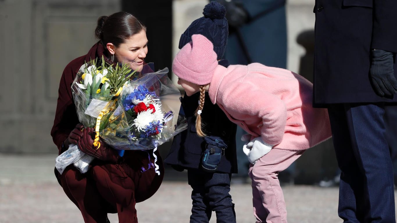 Prinzessin Victoria lässt ihre Kinder Oscar und Estelle an geschenkten Blumen schnuppern.