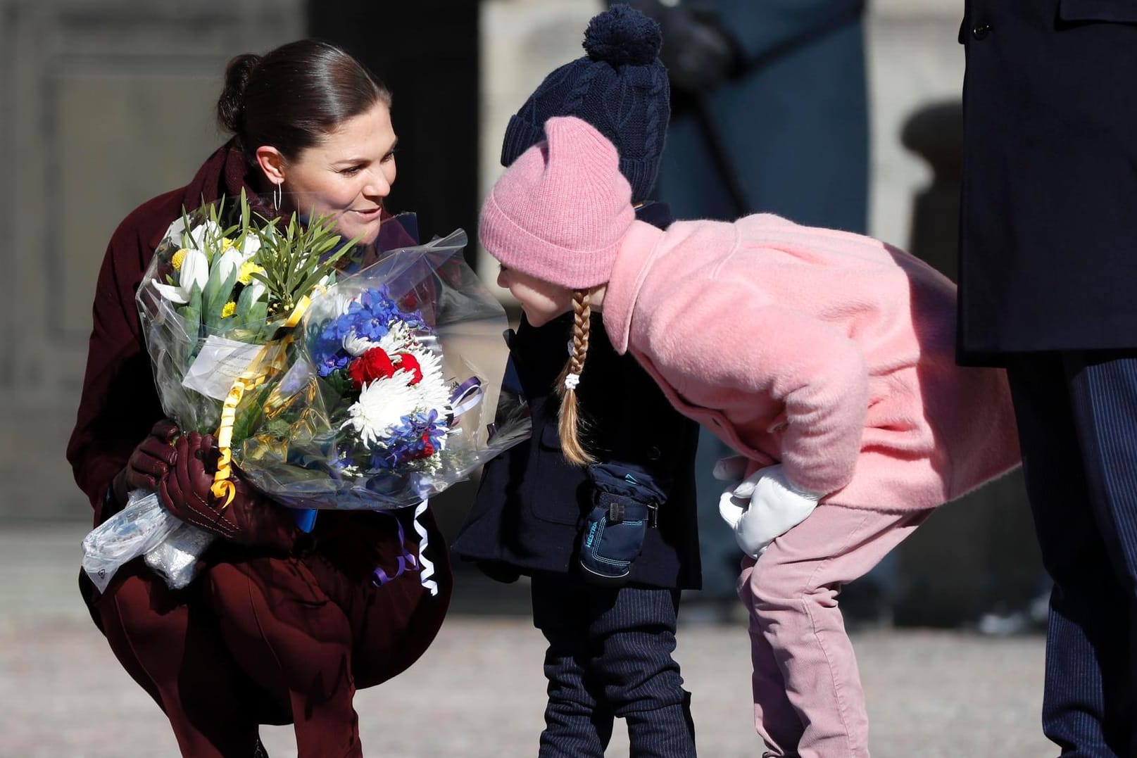 Prinzessin Victoria lässt ihre Kinder Oscar und Estelle an geschenkten Blumen schnuppern.