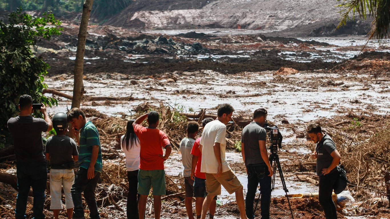 Menschen stehen nach dem Bruch eines Staudamms an der Feijão Eisenerzmine