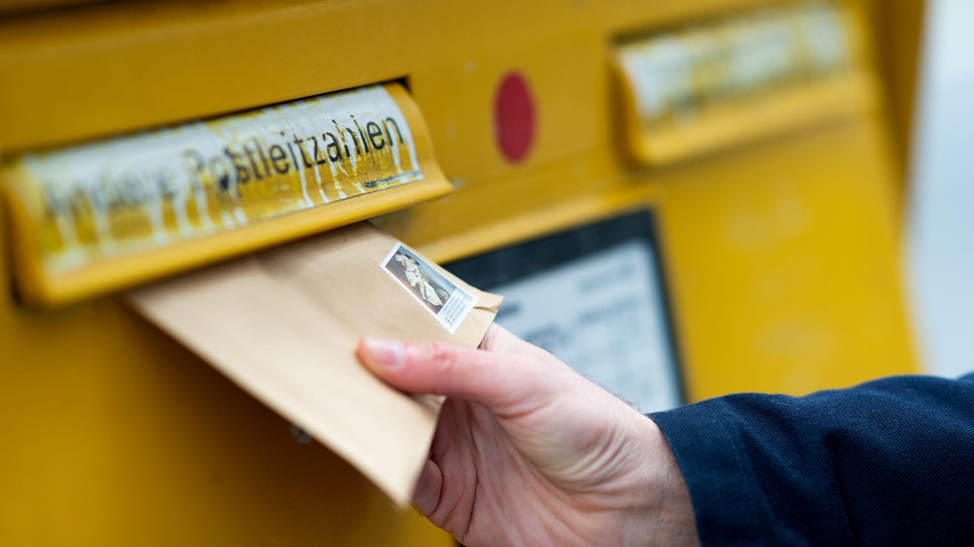 Ein Mann wirft einen Brief in einen Briefkasten (Symbolbild): Eine tote Maus in einem Brief löste einen Großeinsatz aus.