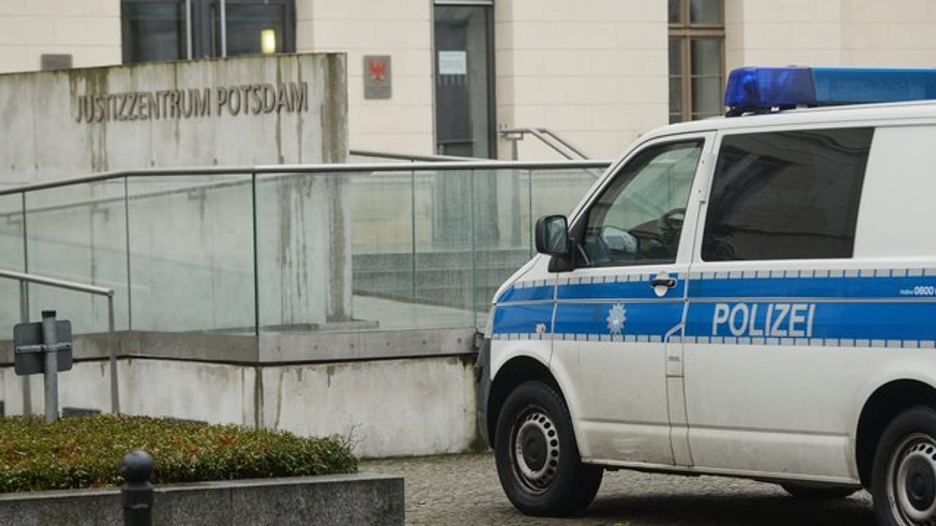 Nach einer Bombendrohung von Rechtsextremisten steht ein Polizeifahrzeug am Justizzentrum Potsdam.