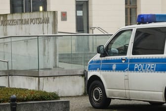 Nach einer Bombendrohung von Rechtsextremisten steht ein Polizeifahrzeug am Justizzentrum Potsdam.
