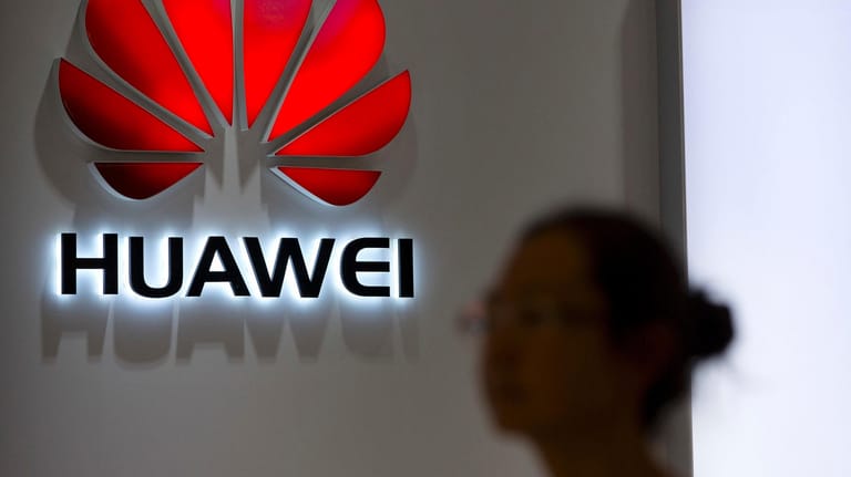 Eine Passantin blickt auf das Logo an einem Huawei Store in Peking: Die Bundesnetzagentur hält den von den USA geforderten Ausschluss des chinesischen Huawei-Konzerns vom deutschen 5G-Netz für problematisch.