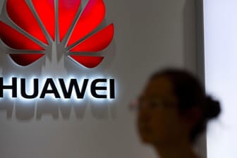 Eine Passantin blickt auf das Logo an einem Huawei Store in Peking: Die Bundesnetzagentur hält den von den USA geforderten Ausschluss des chinesischen Huawei-Konzerns vom deutschen 5G-Netz für problematisch.