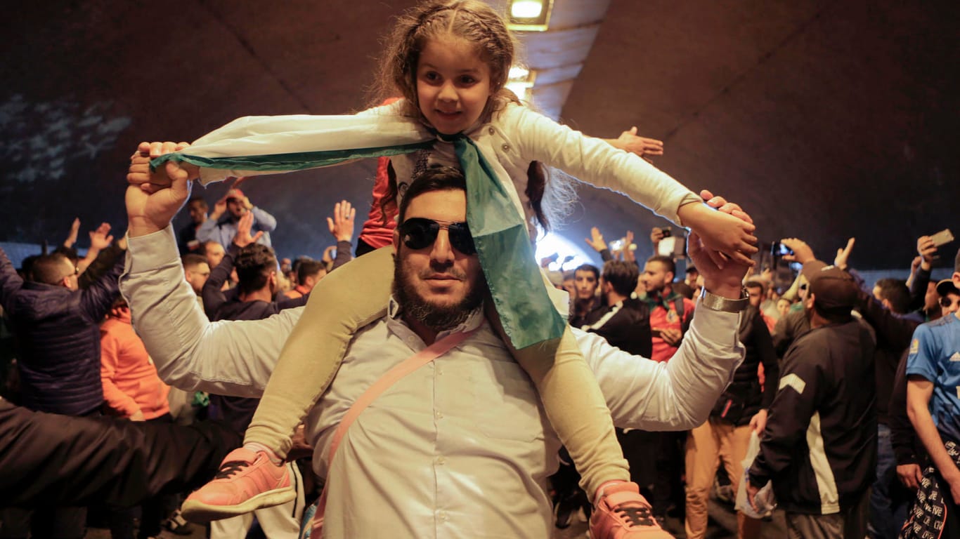 Ein Mann trägt bei einer Kundgebung in Algier ein Mädchen auf den Schultern: Trotz der Reformversprechen der algerischen Regierung gehen die Massenproteste gegen Präsident Bouteflika unvermindert weiter.