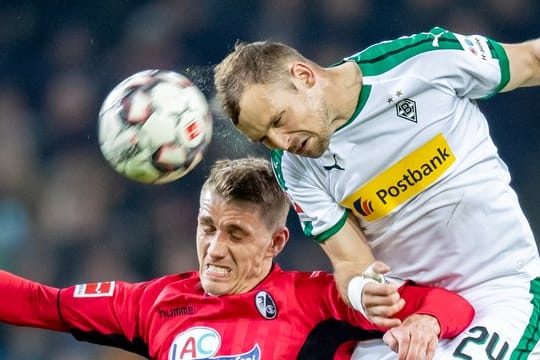 Freiburgs Nils Petersen (l) im Kopfballduell mit dem Gladbacher Tony Jantschke.
