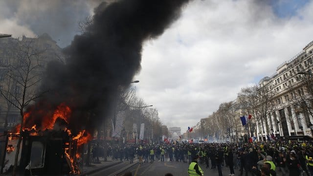 Ein Kiosk steht auf den Champs-Elysees in Flammen.