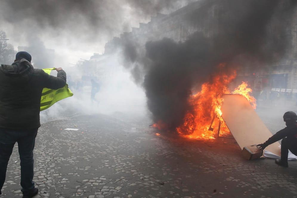 Demonstranten setzen eine Barrikade auf dem Champs-Élysées in Brand: Bei den "Gelbwesten"-Protesten ist es zu Ausschreitungen gekommen.